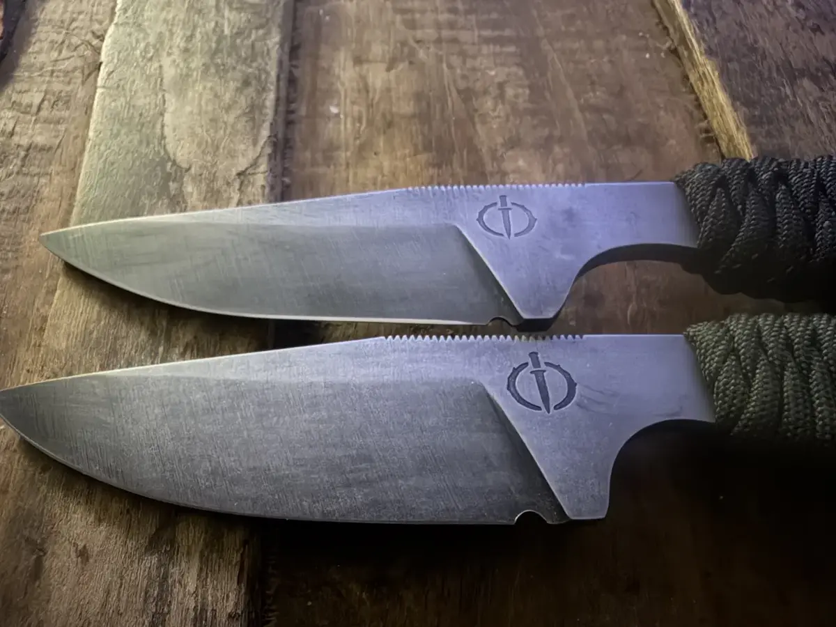 The Crusader fixed-blade pair with black and olive paracord-wrapped handles